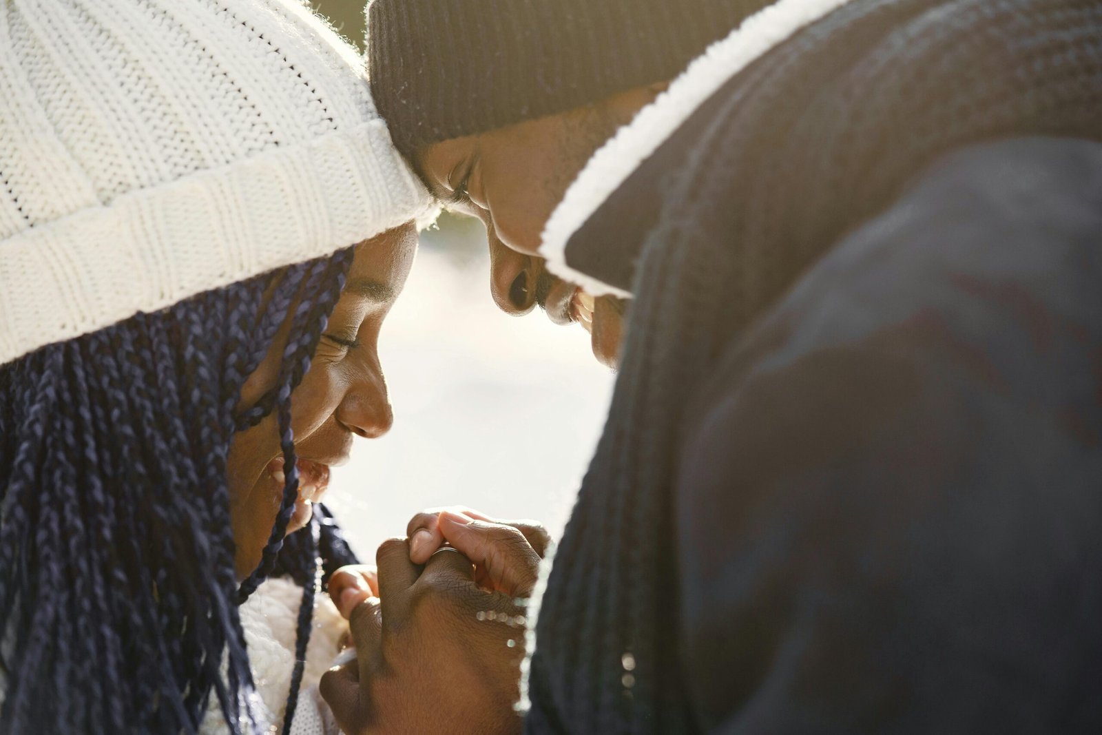 Close-up of a loving couple sharing an intimate moment outdoors in winter attire.